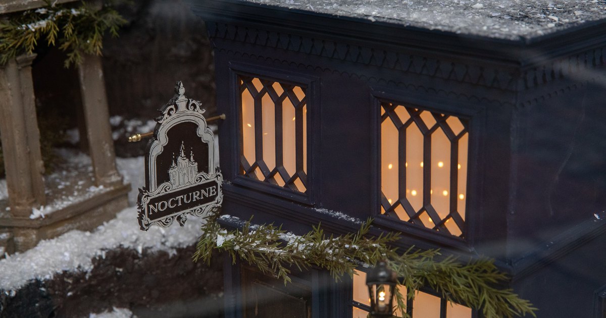 Miniature Salem storefront decorated with snow and winter greenery