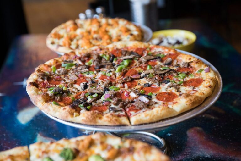 Two pizzas on raised serving stands at Flying Saucer Pizza Company in Salem