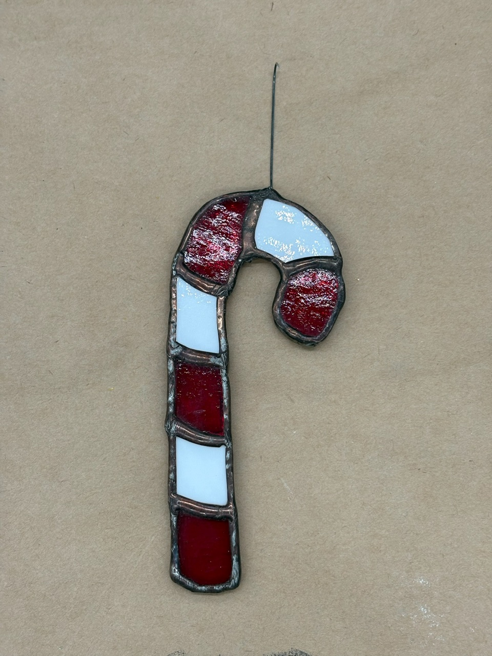 Red and white stained glass candy cane ornament from a North Shore Glass School workshop