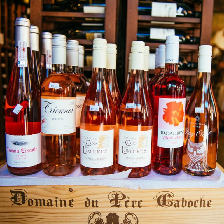 Row of rosé wine bottles displayed on a wooden wine crate at Salem Wine Imports